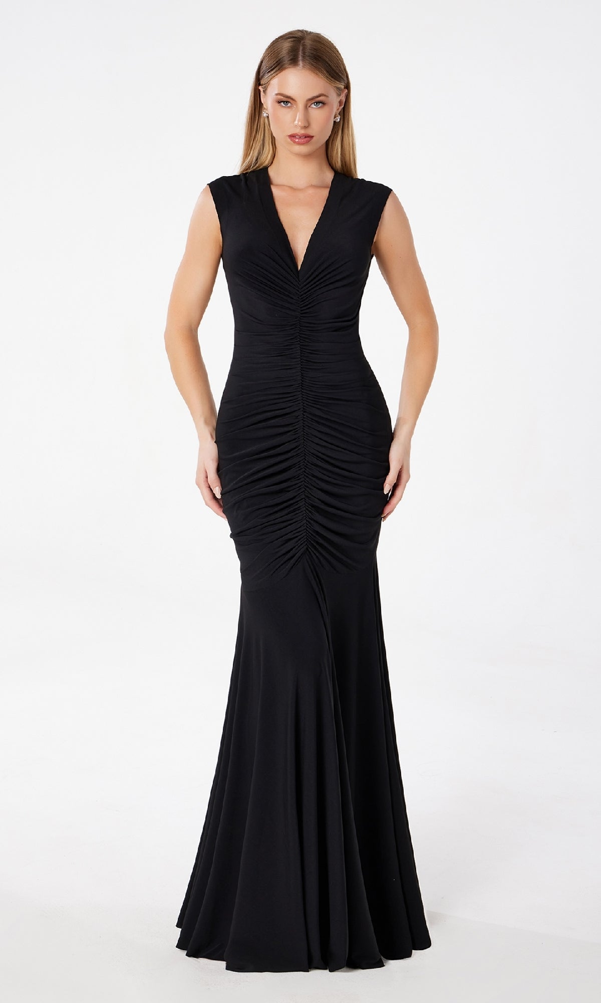 A woman stands against a white background wearing the Astee T2009 Cap-Sleeve Long Ruched Prom Dress, featuring a floor-length design and ruched detailing down the front.